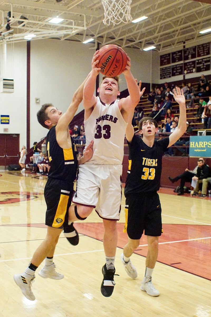 Westside Eagle Observer/RANDY MOLL Gentry senior Dylan Kilgore shoots under the basket while guarded by Prairie Grove senior Riley Rhodes and junior Alex Edmiston during Friday's (Jan. 11, 2019) game at Gentry High School.