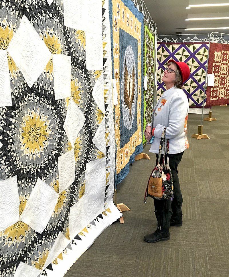 Westside Eagle Observer/RANDY MOLL Mary Thornton, of Jay, Okla., looks at the collection of quilts on display in the McKee Community Room of Gentry Public Library on Friday (Jan. 11, 2019). The annual quilt show, sponsored by the Gentry Chamber of Commerce and McKee Foods, features 35 quilts and will be open daily through Friday of this week. Hours are from 10 a.m. to 5 p.m. daily, and admission is free.