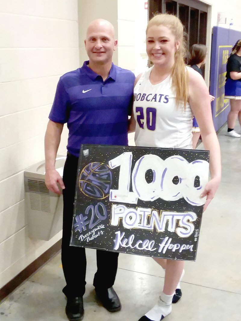 MARK HUMPHREY ENTERPRISE-LEADER/Berryville senior Kelcee Hopper (right) poses with Lady Bobcat girls basketball coach Daniel Cornelison after scoring the 1000th point of her high school career. In doing so she became the fifth player involved in Berryville's 54-25 win over Farmington Tuesday, to reach the milestone along with teammates Baylea Smith and Hannah Morrell plus Makenna Vanzant and Madisyn Pense, of Farmington.