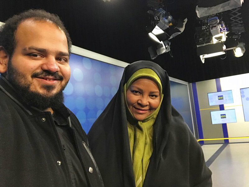 In this undated photo provided by Iranian state television's English-language service, Press TV, American-born news anchor Marzieh Hashemi, right, smiles as she stands with her son in Tehran, Iran. The elder son of Hashemi says his mother is being held in the United States, but has not been charged with anything. Hussein Hashemi says she was detained Sunday, Jan. 13, 2019, as she was leaving St. Louis for Denver. He says she had filmed a Black Lives Matter documentary in St. Louis after visiting family in New Orleans. (Press TV via AP)