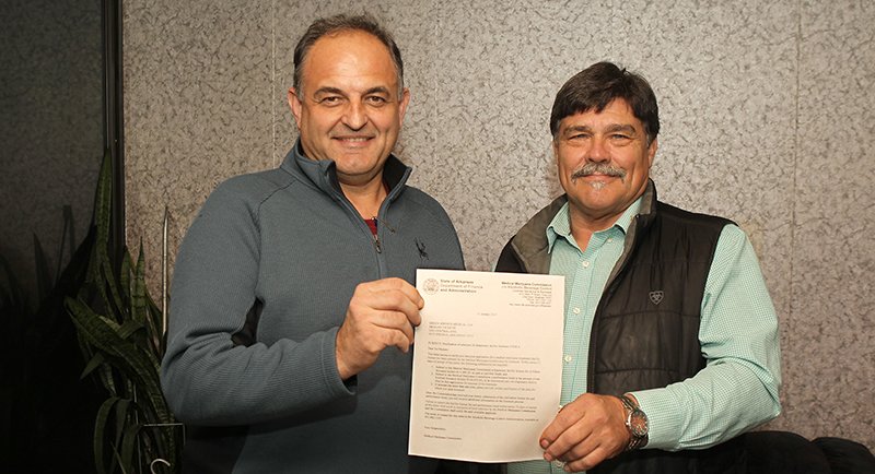 The Sentinel-Record/Richard Rasmussen GREEN LIGHTED: Dragan Vicentic, left, and Bruce Simpson display a letter Wednesday notifying them of the state’s intent to award their company one of four medical marijuana dispensary licenses allocated for Zone 6. They plan to open the dispensary by early May.