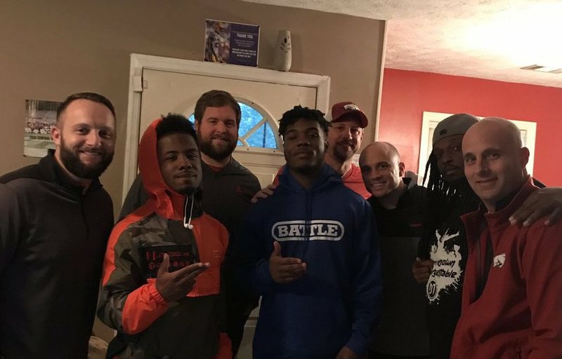 Arkansas' offensive staff pose with running back commitment A'Monate Spivey and family. 