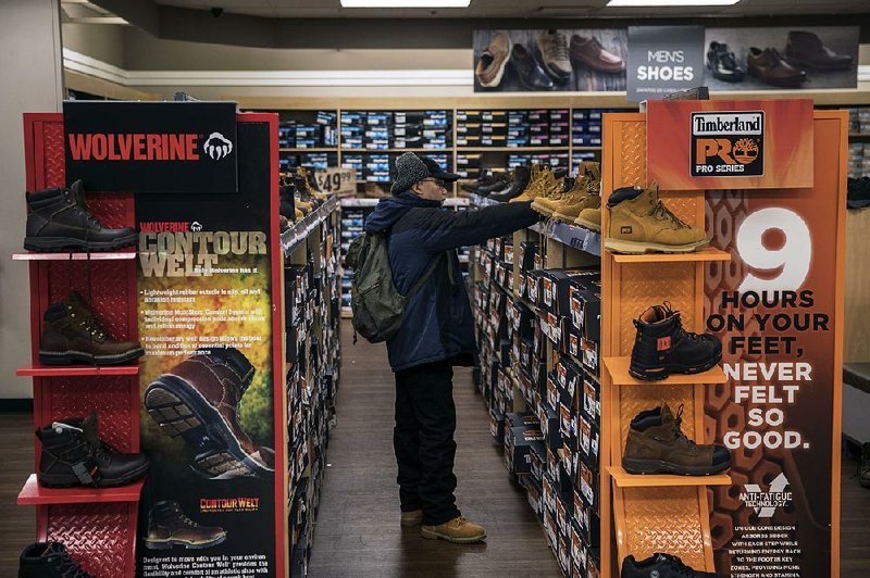 A shopper examines boots at a Sears store in Jersey City, N.J., in November. Sears Holdings Corp. again avoided a closing Wednesday. 