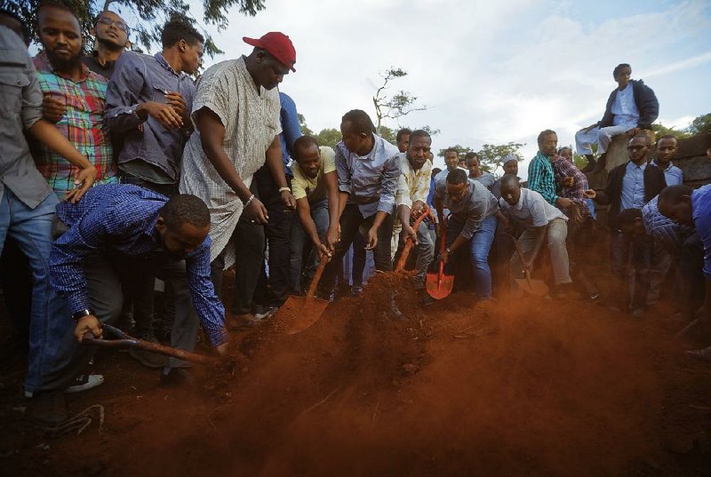 Mourners bury Abdalla Dahir near the grave of his colleague Feisal Ahmed on Wednesday in Nairobi, Kenya. Both were killed in Tuesday’s attack. 