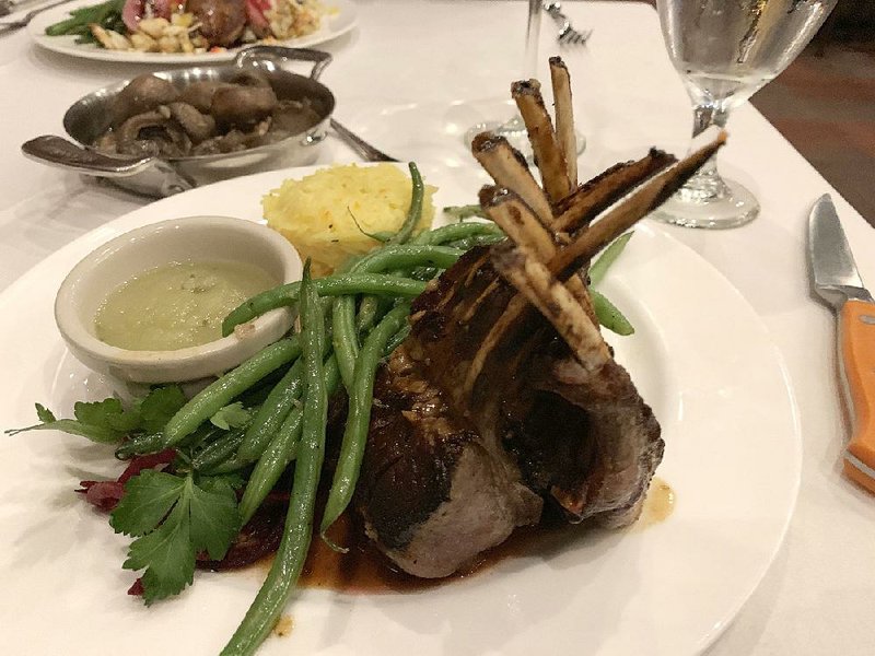 The Dijon Garlic Encrusted Spring Lamb Rack consists of eight perfectly cooked chops, served with mint sauce and the chef’s choice of sides — saffron rice and green beans — at Arthur’s Prime Steakhouse. 