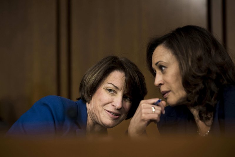 Senators Amy Klobuchar, D-Minn., and Kamala Harris, D-Calif., speak quietly during a congressional hearing. Washington Post photo by Melina Mara