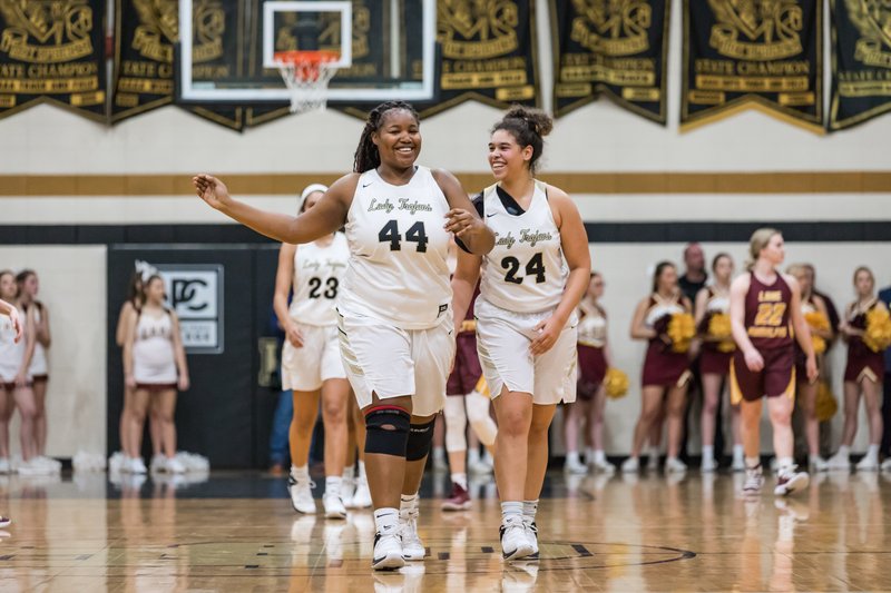 HOME COURT: Hot Springs senior Bre Collins (44) and sophomore Jurnee Hicks (24) react to a play Tuesday inside Trojan Fieldhouse during a 38-32 home victory against the Lake Hamilton Lady Wolves.