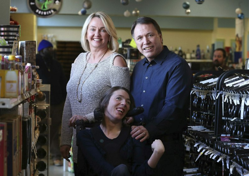 In this image provided by Karen Pulfer Focht, Doug Ketchum and his wife Mary pose with their daughter Stacie as their Memphis liquor store, Kimbrough Wine & Spirits. The U.S. Supreme Court is set to hear a dispute over Tennessee's residency requirements for liquor store owners. Doug and Mary Ketchum moved from Utah to Memphis and say Tennessee makes it almost impossible for someone to break into the liquor business from out of state. (Karen Pulfer Focht)