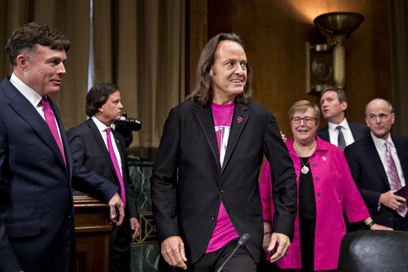 John Legere, chief executive officer of T-Mobile US Inc. (center) arrives at a Senate hearing in Washington, D.C., on June 27, 2018. Bloomberg photo by Andrew Harrer.