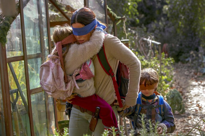 This image released by Netflix shows Sandra Bullock in a scene from the film, "Bird Box." Netflix's post-apocalyptic survival film is drawing criticism for using footage of a real fiery train disaster but the streaming giant has no plans to remove it. The footage concerns a 2013 tragedy in the Quebec town of Lac-Megantic when an unattended train carrying crude oil rolled down an incline, came off the tracks and exploded into a massive ball of fire, killing 47 people. (Saeed Adyani/Netflix via AP)
