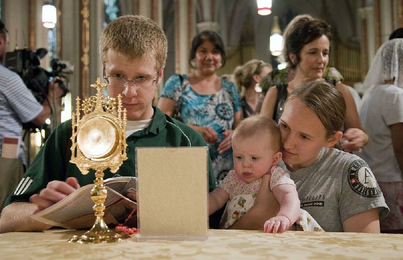 Bryan and Arlene Fair examine a fragment from the crown of thorns at St. Francis de Sales Oratory in St. Louis. The exhibition of more than 150 relics, collectively known as “Treasures of the Church,” were on display Friday at St. Michael’s Catholic Church in Van Buren and will visit Catholic churches in Fort Smith, Russellville, Conway, Jonesboro and Mena on its latest tour through Arkansas.