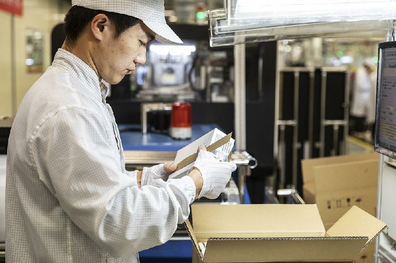 An employee works on the assembly line of a Huawei Technologies mobile-phone plant in Dongguan, China. 