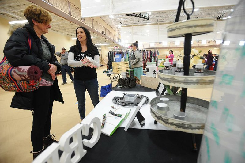 Teressa Sworsky talks with potential customers and explains the benefits of hemp oil and other cannabidiol products at a flea market event in Mokena, Ill. 