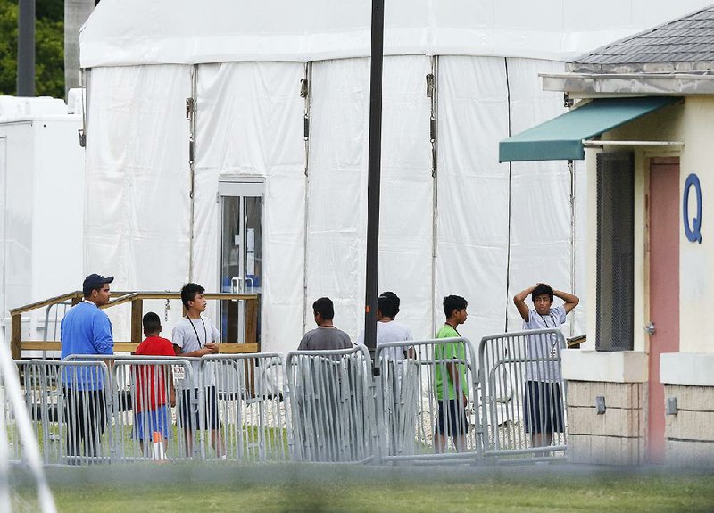 Migrant children stand outside the Homestead Temporary Shelter for Unaccompanied Children in Homestead, Fla., on June 20, 2018.