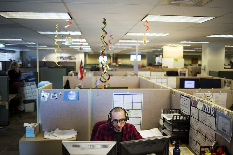 An agent takes calls at the Colorado Department of Labor and Employment in Denver, where a team of nine employees has been set up just to handle inquiries from federal workers.