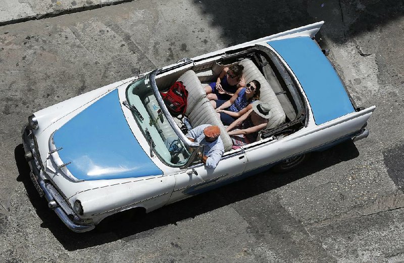 Tourists take a ride in a classic 1956 Dodge Coronet convertible in 2015, before the rules changed for American travelers to Cuba. 