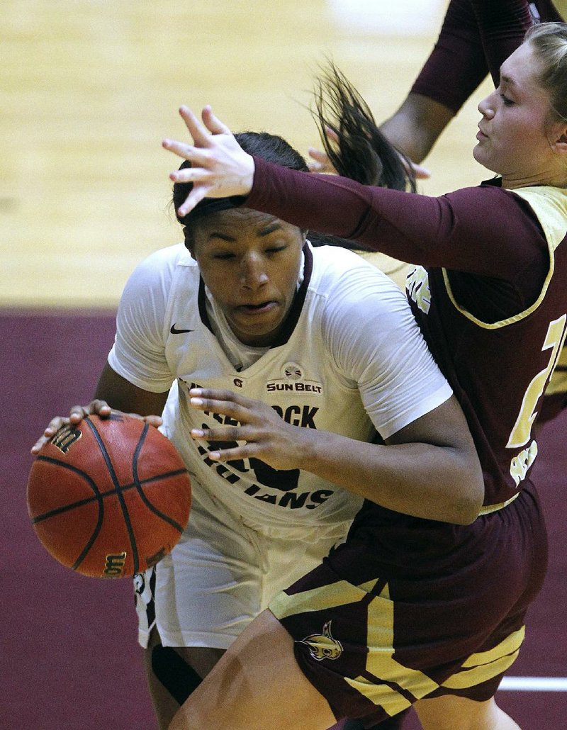 UALR’s Ronjanae DeGray (left) tries to get around Texas State’s Brooke Holle during the fourth quarter Thursday at the Jack Stephens Center in Little Rock. DeGray had 13 points and a game-high 11 rebounds to help the Trojans win 62-47. More photos from this game are available at arkansasonline.com/galleries.