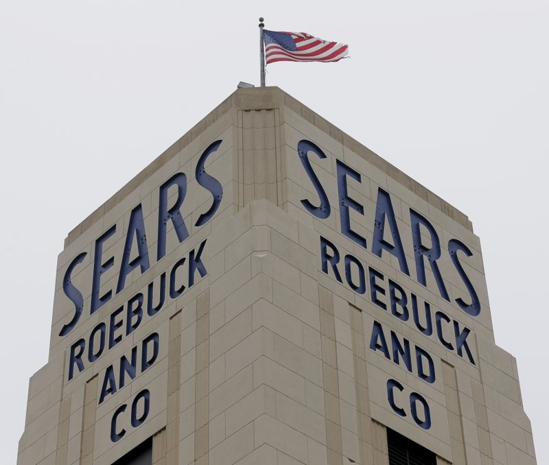 FILE- In this Jan. 8, 2019, file photo an American flag flies above a Sears store in Hackensack, N.J. Sears confirmed Thursday, Jan. 17, that chairman and largest shareholder Eddie Lampert&#x2019;s hedge fund has won tentative approval for a $5.2 billion plan to buy 425 stores and the rest of its assets. (AP Photo/Seth Wenig, File)