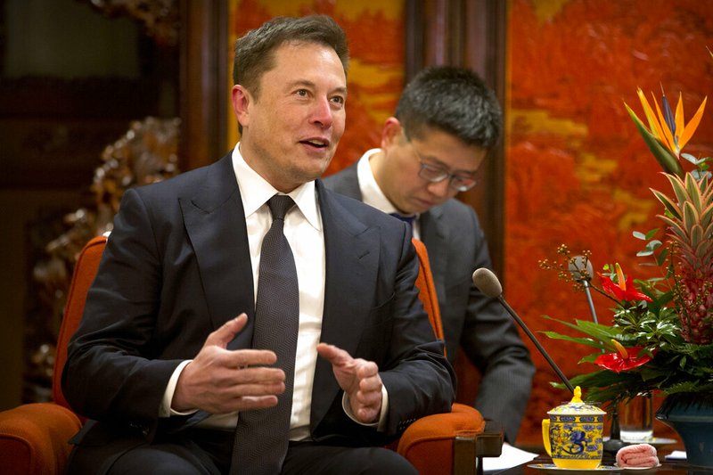 In this Jan. 9, 2019, file photo, Tesla CEO Elon Musk speaks during a meeting with Chinese Premier Li Keqiang at the Zhongnanhai leadership compound in Beijing. Electric car and solar panel maker Tesla said Friday, Jan. 18, 2019 it plans to cut its staff by about 7 percent. (AP Photo/Mark Schiefelbein, Pool, File)