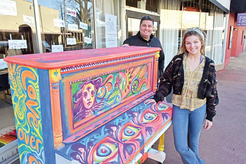 Mat Faulkner, director of the Think ART Project in Searcy, stands with Harding University senior Raeanne Kiihnl, also of Searcy, an artist who painted one of the pianos in the Think ART Project piano initiative. Faulkner said the donated pianos will be painted by different artists and displayed inside businesses and outside as pieces of art, as well as for people to play.