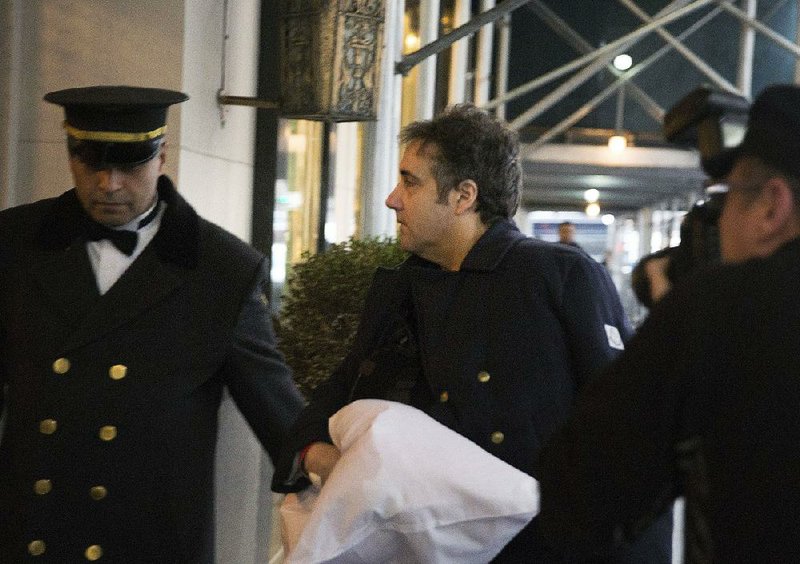 Michael Cohen, President Donald Trump’s former lawyer, arrives at his home Friday in New York with his left arm in a sling supported by a pillow. 