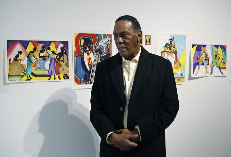 The Associated Press PRISON PAINTINGS: Richard Phillips stands next to some of his artwork during an interview, Thursday at the Community Art Gallery in Ferndale, Mich. Phillips was exonerated of murder in 2018 after 45 years in prison. Lawyers say he should be entitled to more than $2 million under Michigan's wrongful conviction law, but the state so far is resisting. So Phillips, 73, is selling some of his 400-plus watercolors that he painted in prison.