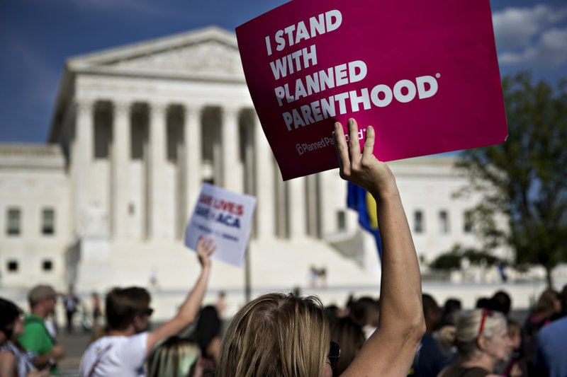 A demonstrator opposed to the Senate Republican health-care holds a sign that reads "I Stand With Planned Parenthood" while marching near the U.S. Supreme Court in Washington on June 28, 2017. Bloomberg photo by Andrew Harrer.