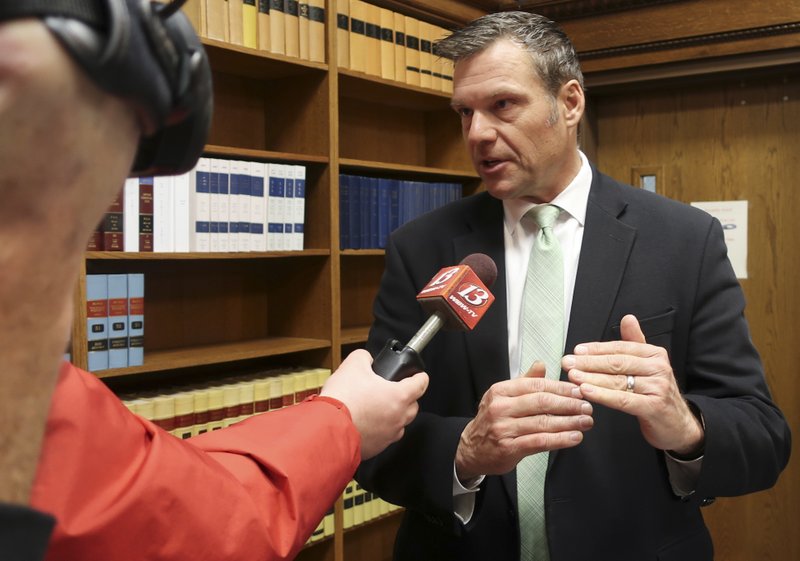 In this Nov. 30 2018 file photo, former Kansas Secretary of State Kris Kobach answers questions from reporters in Topeka, Kan. The future of a contentious multi-state voter registration database is uncertain now that former Kansas Secretary of State Kobach no longer holds that office.  (AP Photo/John Hanna File)