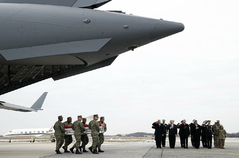 A Navy team carries the remains of civilian Scott Wirtz past President Donald Trump and other officials Saturday at Dover Air Force Base in Delaware. Wirtz was one of four Americans killed in Manbij, Syria, last week. The transfers of the other victims’ remains were conducted in private, with the president observing. He also visited with the families. 