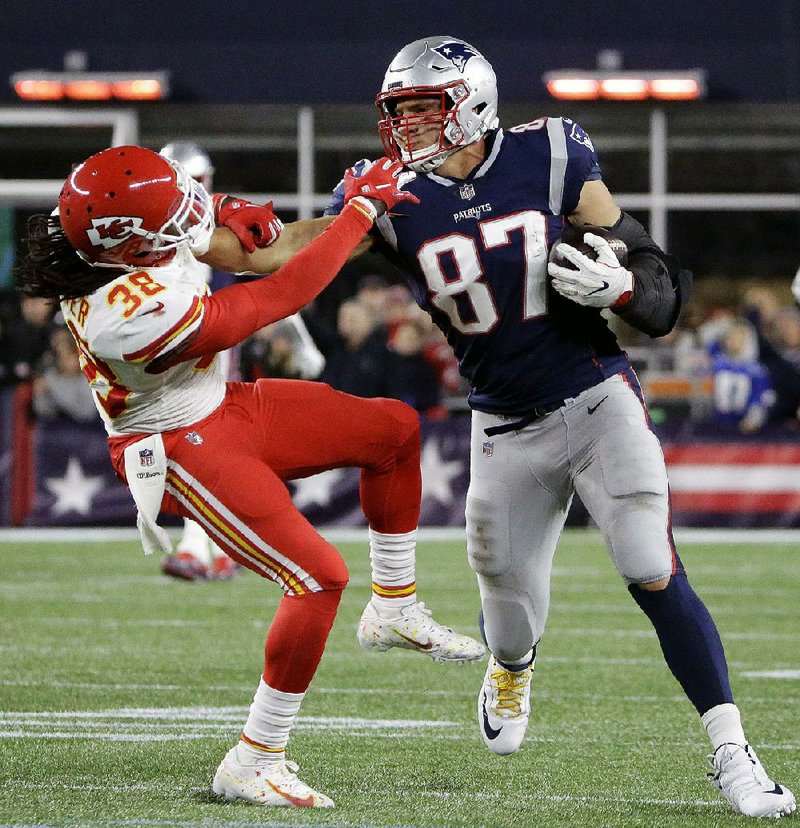 New England tight end Rob Gronkowski (87) gives a stiff arm to Kansas City free safe- ty Ron Parker after catching a pass during the Patriots’ victory over the Chiefs earlier this sea- son. Coach Bill Belichick said there is little to take away from the Week 6 victory, and Patriots’ players have said they’re in for a tough test today in the AFC Championship Game.