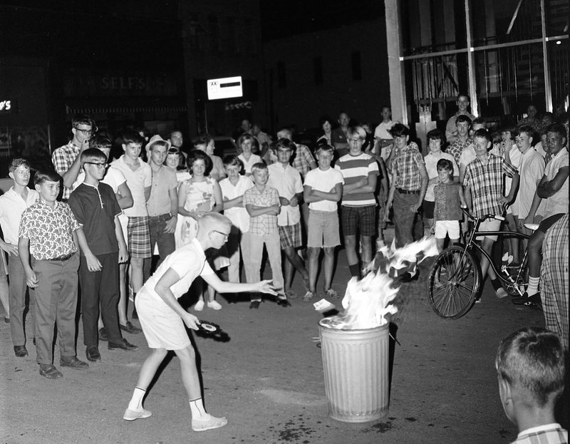 Courtesy Shiloh Museum of Ozark History / Springdale News Collection / Charles Bickford, photographer David McKinney throws Beatles records into the fire in Springdale on Aug. 15, 1966. "We produce two photo exhibits a year, so I'm always on the lookout for possible topics with broad appeal," says Shiloh Museum photo archivist Marie Demeroukas. To get viewers "in the proper mindset" for the "Stand Up, Speak Out" exhibit on protests, the museum will offer a "selfie station." "Visitors can 'stand up and speak out' about an issue important to them by writing a message on a dry-erase board and holding it up in front of a colorful backdrop," she says.