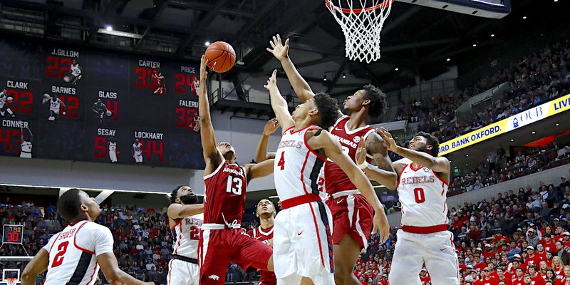 The Associated Press GROUNDED: Arkansas guard Mason Jones (13) attempts a shot over Ole Miss guard Breein Tyree (4) Saturday during the Rebels' 84-67 home win over the Razorbacks in Oxford, Miss.