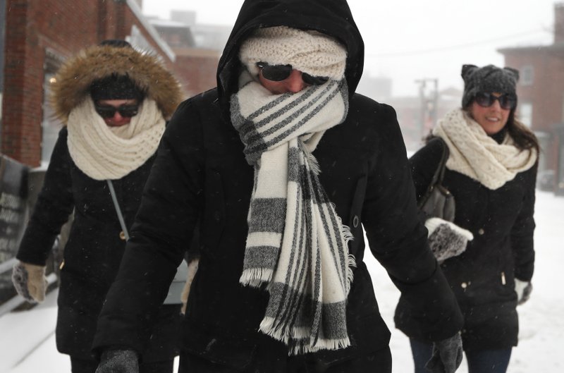 Julia Beebe, center, Shannon Amore, left, and Jessica Lynch brave a winter storm to keep a lunch date, Sunday in Portland, Maine. Scarves, hoods and gloves were necessary for New England residents venturing outdoors as the region endures a storm that can dump up to 18 inches of snow. (AP Photo/Robert F. Bukaty)


