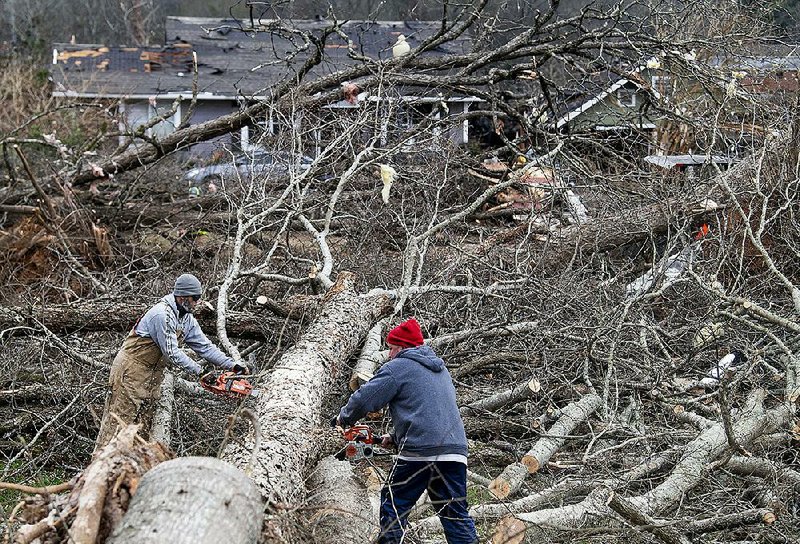Workers remove downed trees Sunday after a tornado struck Wetumpka, Ala., on Saturday afternoon.