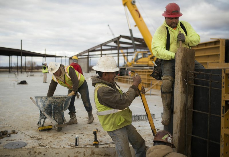 NWA Democrat-Gazette/CHARLIE KAIJO Construction workers Ramon Herndez, Mateo Carmona and Luis Recinos (from left) build a wall in December at the site of the new U.S. Marshals Museum in Fort Smith. The building is expected to be completed by September. A special election will be held in March to help finish the museum and exhibits.