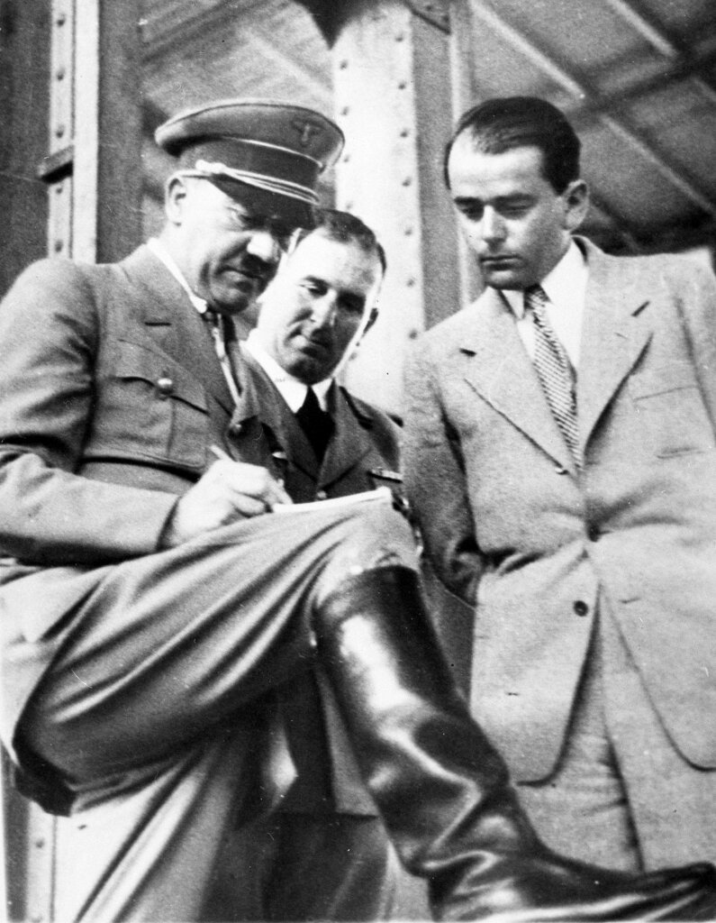 FILE - In this file photo dated Feb. 19, 1937, German Chancellor Adolf Hitler, left, discusses plans for building a convention hall at Nuremberg with Lord Mayor Willy Liebel, centre, and Prof. Albert Speer, right, at Nuremberg, Germany. Hilde Schramm inherited several paintings collected by her father, Hitler's chief architect and Armaments Minister Albert Speer, but she didn't want them. Instead, Schramm sold them and used the money to start the Zurueckgeben foundation, translated to "return" or "give back", for which she is receiving an Obermayer German Jewish History Award on Monday Jan. 21, 2019. (AP Photo, File)