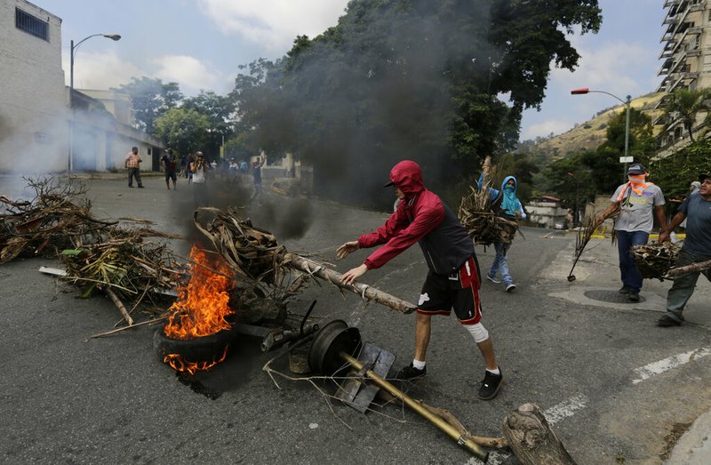 Anti-government protesters create burning roadblocks during clashes with security forces, as they show support for a mutiny by a National Guard unit in the Cotiza neighborhood of Caracas, Venezuela, Monday, Jan. 21, 2019. Venezuela's government said Monday it put down the mutiny. (AP Photo/Fernando Llano)