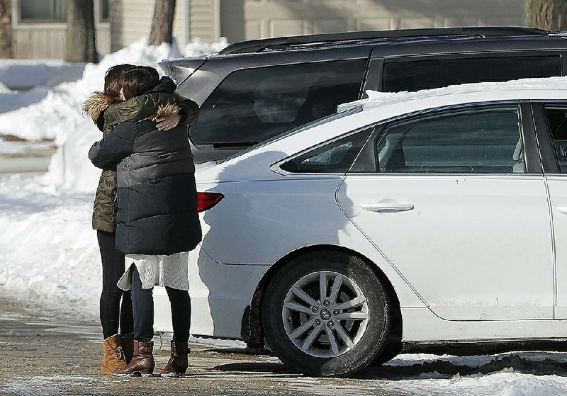 People hug each other Monday near the scene where a 12-year-old girl died Sunday after a snow fort collapsed while she was playing outside Rothem Church in Arlington Heights, Ill. 