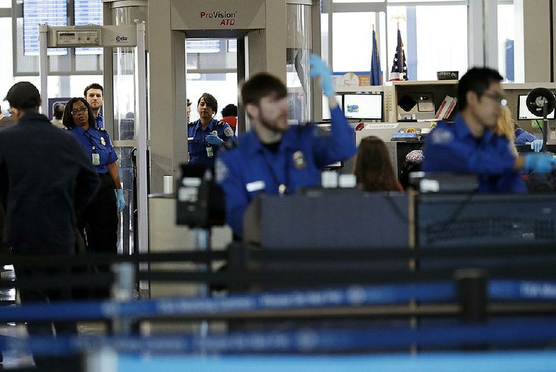 Transportation Security Administration officers work at a check- point at O’Hare airport in Chicago earlier this month. 