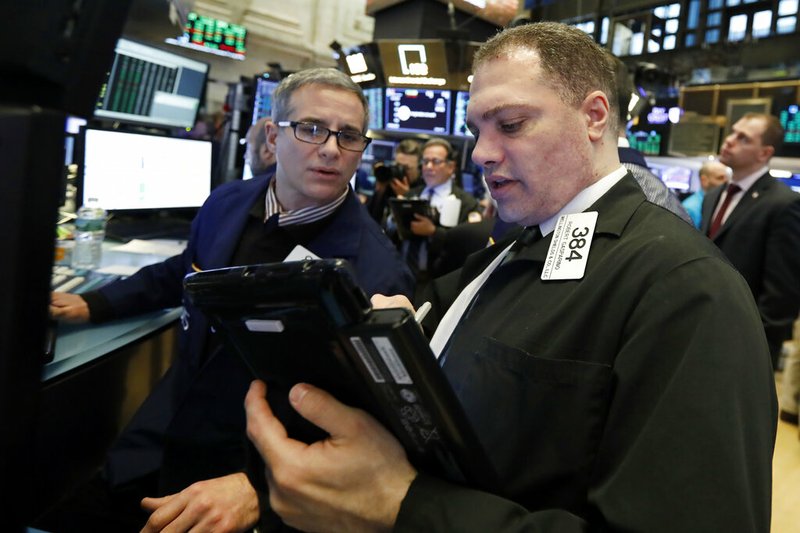 FILE- In this Jan. 18, 2019, file photo specialist Anthony Rinaldi, left, and trader Robert Gasparino work on the floor of the New York Stock Exchange. The U.S. stock market opens at 9:30 a.m. EST on Tuesday, Jan. 22. (AP Photo/Richard Drew, File)