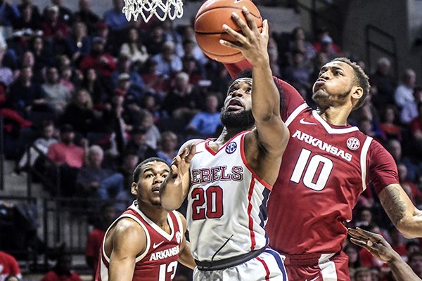 Mississippi guard D.C. Davis (20) shoots against Arkansas guard Mason Jones (13) and Arkansas forward Daniel Gafford (10) in Oxford, Miss., on Saturday, Jan. 19, 2019. (Bruce Newman/The Oxford Eagle via AP)

