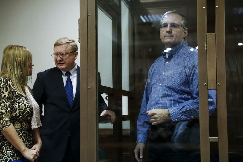 Paul Whelan looks through a glass cell Tuesday as his lawyers confer during a court session in Moscow, where the former U.S. Marine is facing spying charges. Whelan was arrested Dec. 28 after reportedly being given a flash drive that contained a full list of employees’ names at a secret Russian security agency. His lawyers said he thought the drive contained pictures of churches. 
