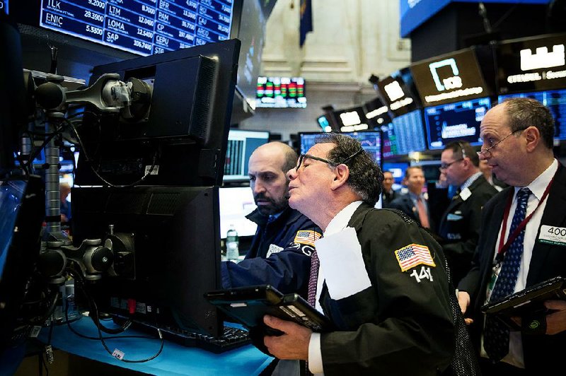 Traders work Tuesday on the floor of the New York Stock Exchange. The S&P slid into correction territory Tuesday. 