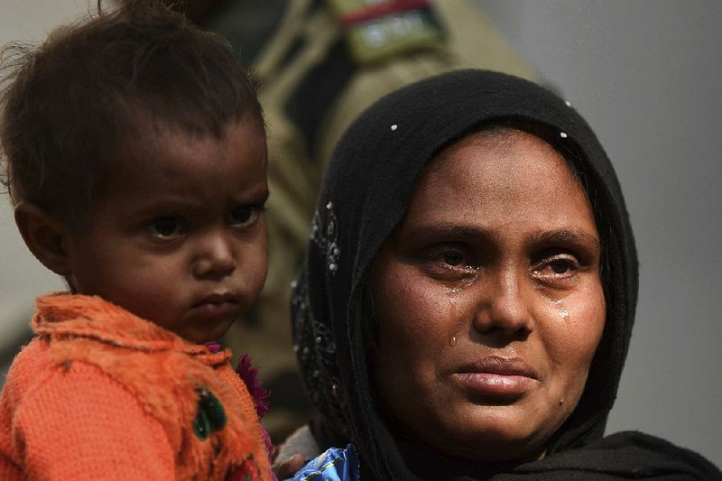 A Rohingya Muslim woman cries Tuesday outside a police station in Agartala, India, after she and her child were arrested. 