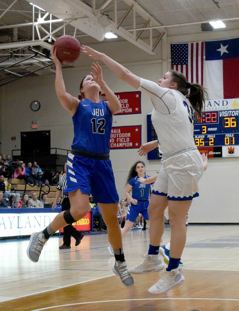 Photos courtesy of Wayland Baptist John Brown junior Jordan Martin goes up for a shot as Wayland Baptist's Kaylee Edgemon defends during the Flying Queens' 90-49 victory on Saturday.