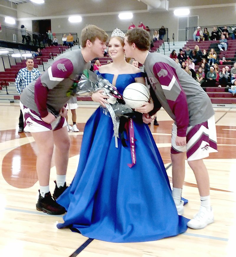 MARK HUMPHREY ENTERPRISE-LEADER Lincoln Colors Day queen, senior Averi Massey, daughter of Allen Massey, and Kevin and Olivia Barenberg, receives kisses from escorts, senior Caleb Hale (left), son of Matt and Melissa Hale; and senior Sterling Morphis, son of Russell Morphis and Mandi Kester.