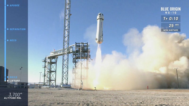 In this image from video made available by Blue Origin, the New Shepard capsule and booster lifts off from the company's site in west Texas. Jeff Bezos' rocket company launched NASA experiments into space on the brief test flight. (Blue Origin via AP)