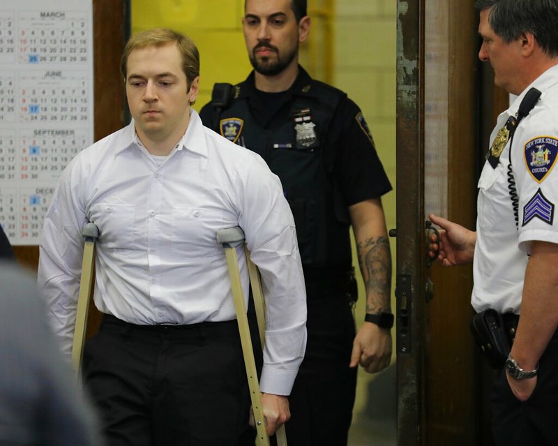 James Jackson, using crutches, is escorted into criminal court, Wednesday Jan. 23, 2019 in New York. Jackson, a white supremacist, pled guilty Wednesday, to killing a black man with a sword as part of a racist plot that prosecutors described as a hate crime. He faces life in prison when he is sentenced on Feb. 13. (AP Photo/Bebeto Matthews)