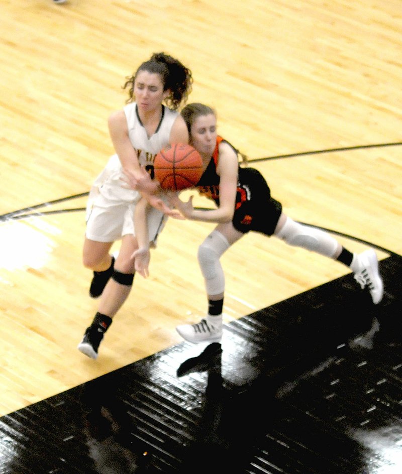 MARK HUMPHREY ENTERPRISE-LEADER Gravette sophomore Kaylan Chilton jumps a pass intended for Prairie Grove senior Lexie Madewell. Their collision resulted in an all-out battle for possession of the basketball. Gravette defeated Prairie Grove in 4A-1 Conference girls basketball action, 48-40, on Tuesday, Jan. 8, 2019, at Tiger Arena.