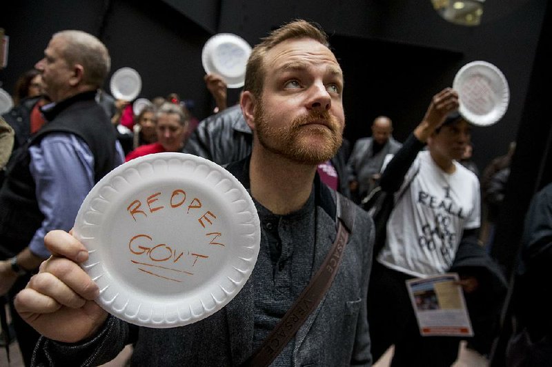 Furloughed federal workers hold a silent protest Wednesday on Capitol Hill. To convey their message and avoid being arrested, they used disposable plates instead of posters. 